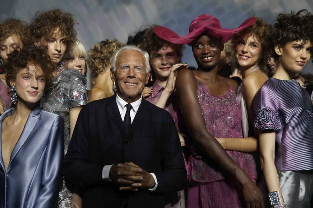 Designer Giorgio Armani poses with models at the end of his women’s 2019 Spring-Summer collection, unveiled during the Fashion Week in Milan, Italy, on Sept. 23, 2018. (AP Photo/File)
