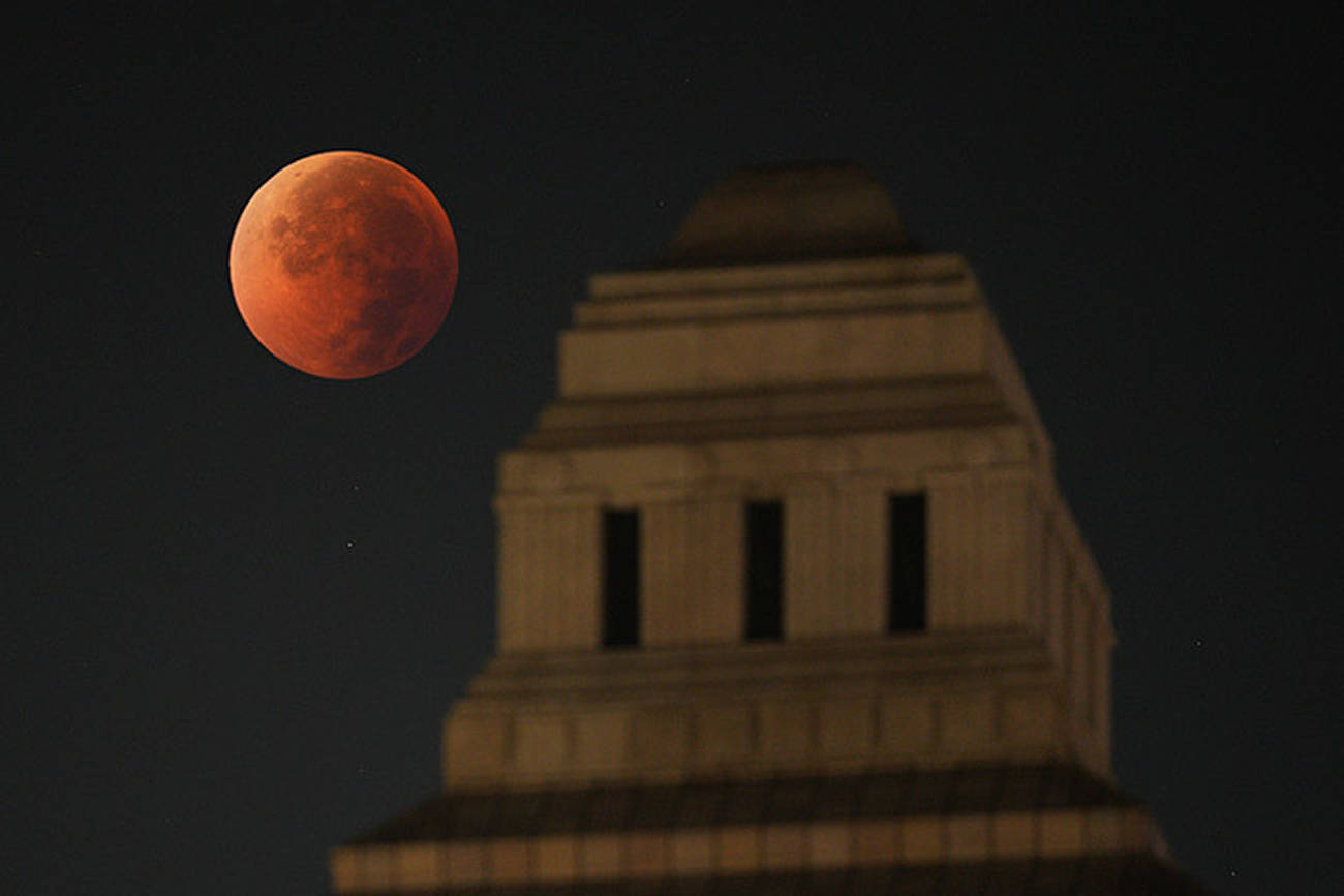 The full moon shines in a copper-reddish color as it entered the Earth's shadow at 3:38 a.m. on Sept. 8. At right is the National Diet Building. (Photo by Hikaru Uchida）